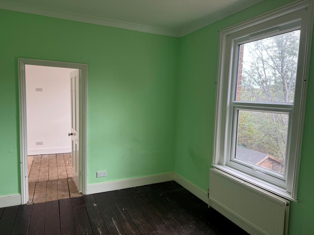 Lot: 80 - FREEHOLD TOWN CENTRE HOUSE COMMERCIAL INVESTMENT AND CAR PARK - Bedroom with wooden floor and green painted walls